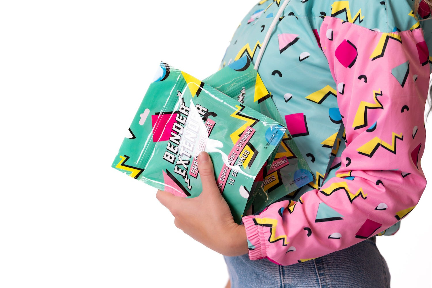 Person wearing a colorful jacket holding a green bag with text on a white background