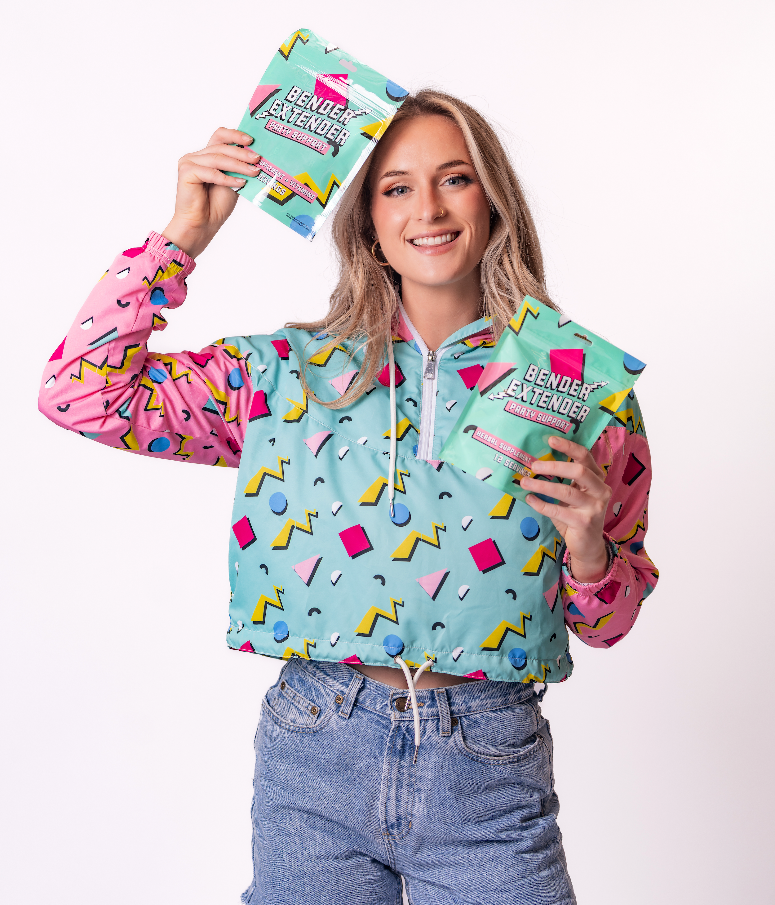 Cameo Hanlon wearing a colorful hoodie with geometric patterns, holding 'Gender Extender' products.